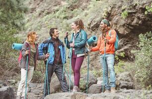 feliz trabalhos equipe amigos fazendo caminhada excursão em montanhas - grupo jovem turistas caminhada e explorando a selvagem natureza - caminhante, caminhar esporte e viagem estilo de vida pessoas conceito foto