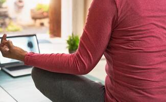 Visão do mulher fazendo ioga virtual ginástica classe com computador portátil às casa - e-learning e pessoas bem estar estilo de vida conceito foto