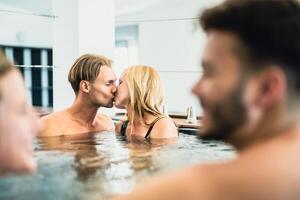 feliz amigos desfrutando Férias dentro jacuzzi luxo casa foto