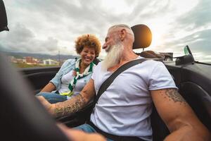 feliz Senior casal tendo Diversão dirigindo em Novo conversível carro - maduro pessoas desfrutando Tempo juntos durante estrada viagem Tour período de férias - viagem pessoas estilo de vida conceito foto