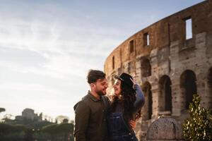 jovem romântico casal tendo concurso momento dentro frente do Roma Coliseu foto