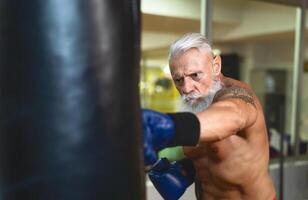 Senior homem boxer Treinamento Difícil - idosos masculino boxe dentro esporte Academia Centro clube - saúde ginástica e desportivo atividade conceito foto