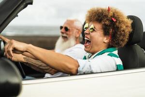 feliz Senior casal tendo Diversão dirigindo em Novo conversível carro - maduro pessoas desfrutando Tempo juntos durante estrada viagem Tour período de férias - idosos estilo de vida e viagem cultura transporte conceito foto