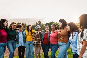 feliz multigeracional grupo do mulheres com diferente idades e etnias tendo Diversão dentro uma público parque - pessoas diversidade conceito foto