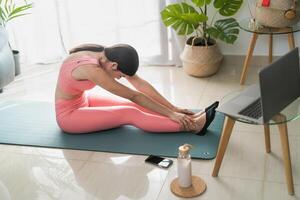 jovem latim mulher fazendo pilates virtual ginástica classe com computador portátil às casa - esporte bem estar pessoas estilo de vida conceito foto