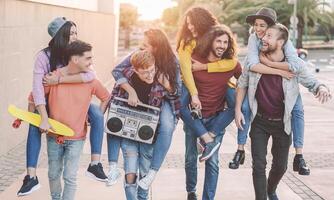 feliz amigos tendo Diversão caminhando pegar carona dentro a cidade Centro. grupo jovem pessoas rindo e partilha Tempo juntos ar livre. juventude cultura amizade pessoas estilo de vida conceito foto