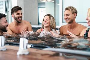 feliz amigos desfrutando Férias dentro jacuzzi luxo casa - jovem pessoas tendo Diversão juntos dentro quente banheira - juventude milenar geração e bem estar estilo de vida feriados foto