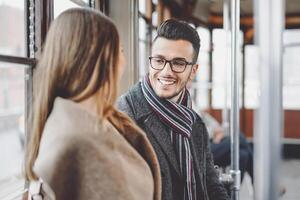 feliz casal tendo conversação enquanto indo para trabalhos dentro ônibus - jovem pessoas viajando dentro vintage eléctrico transporte - amor relação e viagem estilo de vida conceito foto