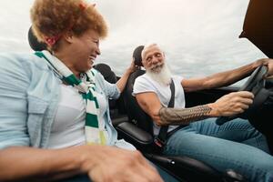 feliz idosos casal tendo Diversão dirigindo conversível carro durante uma estrada viagem - viagem pessoas estilo de vida conceito foto