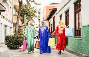 feliz muçulmano mulheres fazendo compras dentro a cidade Centro - árabe adolescente meninas tendo Diversão comprando Novo tradicional árabe roupas dentro Shopping - conceito do pessoas religião, comprador, consumismo e diverso cultura foto