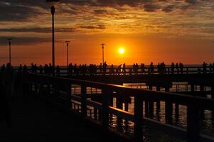 pôr do sol em a cais dentro palanga, báltico mar foto