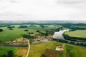 Visão a partir de a altura do a lago dentro uma verde campo dentro a Formato do uma ferradura e uma Vila dentro a mogilev região.bielorrússia.a natureza do bielorrússia foto