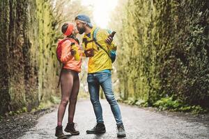 feliz casal se beijando enquanto explorando Turística parque - jovem turista tendo Diversão fazendo excursão dentro selvagem floresta - turismo viagem pessoas amor relação e período de férias estilo de vida conceito foto