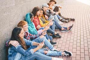 grupo do amigos usando seus inteligente Móvel telefones ao ar livre - milenar jovem pessoas viciado para Novo tecnologia tendências aplicativo - conceito do pessoas, tecnologia, social meios de comunicação, geração z e juventude estilo de vida foto