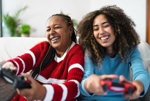 dois mulheres jogando vídeo jogos em uma sofá foto