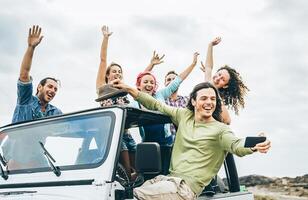 grupo do feliz amigos levando selfie com Móvel inteligente telefone em jipe carro - jovem pessoas tendo Diversão fazer foto durante seus estrada viagem - amizade, férias, juventude feriados estilo de vida conceito