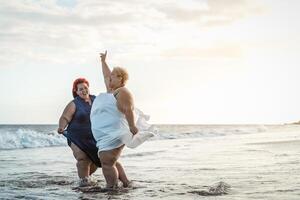 feliz mais Tamanho mulheres tendo Diversão em a de praia durante verão período de férias - cheio de curvas confiante pessoas estilo de vida conceito foto