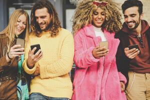 grupo do amigos assistindo em seus Móvel telefones ao ar livre - milenar jovem pessoas tendo Diversão com Novo tecnologia Smartphone tendências - geração z, social meios de comunicação, tecnologia e juventude estilo de vida conceito foto