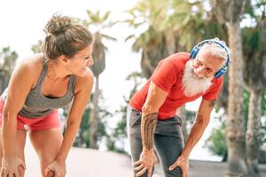 em forma casal do amigos tendo uma pausa depois de uma velozes raça Próximo a de praia às pôr do sol - desportivo pessoas exercite-se ao ar livre - fitness, bem-estar, esporte, corrida e saúde estilo de vida conceito foto