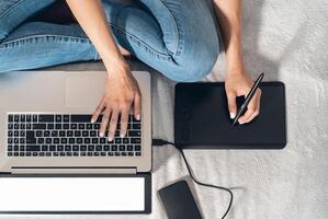 gráfico desenhador mulher inteligente trabalhando em computador às casa - jovem fêmea desenhando com interativo caneta e computador portátil dentro cama - sem fio tecnologia e Projeto freelance trabalho estilo de vida conceito foto