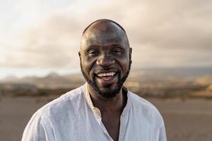 uma homem sorrisos enquanto em pé dentro a deserto foto