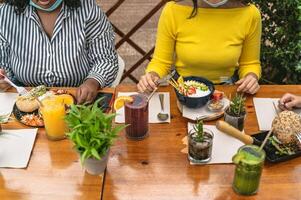 multirracial amigos tendo saudável almoço dentro café Escovar Barra durante corona vírus surto foto