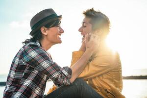 feliz gay casal namoro Próximo a de praia às pôr do sol - jovem lésbica mulheres tendo uma concurso romântico momento ao ar livre - lgbt, homossexualidade amor e estilo de vida relação conceito foto