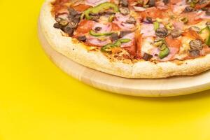delicioso ampla pizza com vitela e cogumelos em uma amarelo fundo foto