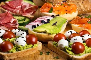 sortido sanduíches com peixe, queijo, carne e legumes deitado em a borda foto