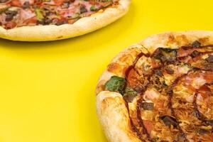 dois diferente delicioso grande pizzas em uma amarelo fundo foto