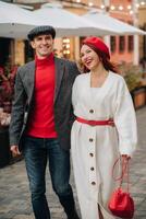 retrato do uma feliz casal caminhando em a rua dentro a outono cidade. à moda casal dentro retro estilo dentro outono dentro a cidade foto