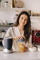 uma menina faz uma desintoxicação coquetel do fruta dentro a cozinha . dieta para peso perda foto