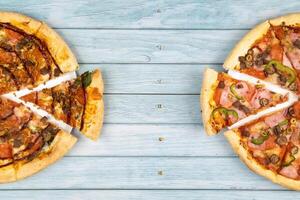 dois diferente delicioso grande pizzas em uma azul de madeira fundo foto