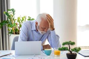 homem de negocios escritório trabalhando segurando dolorido cabeça dor a partir de escrivaninha trabalhando e sentado todos dia usando computador portátil computador ou caderno sofrimento dor de cabeça doente trabalhador excesso de trabalho conceito foto