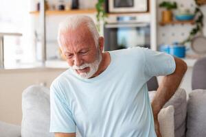 Senior idosos homem tocante dele voltar, sofrimento a partir de dor nas costas, ciática, sedentário estilo de vida conceito. coluna vertebral saúde problemas. assistência médica, seguro foto