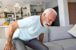 Senior idosos homem tocante dele voltar, sofrimento a partir de dor nas costas, ciática, sedentário estilo de vida conceito. coluna vertebral saúde problemas. assistência médica, seguro foto