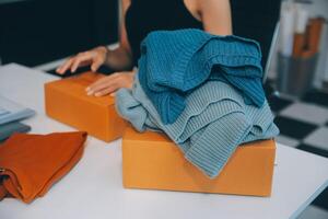 moda blogueiro conceito, jovem ásia mulheres vendendo roupas em vídeo streaming.startup pequeno o negócio sme, usando Smartphone ou tábua levando receber e verificação dentro casa escritório foto