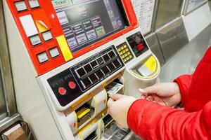 mão do pessoas compra metrô bilhetes através japonês automatizado bilhete máquinas às metrô estação dentro Osaka cidade. foto