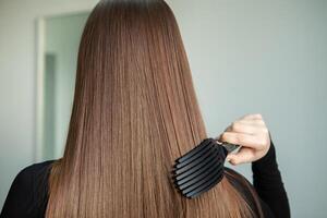 retrato do uma lindo mulher com grandes Castanho em linha reta cabelo dentro uma beleza salão. foto