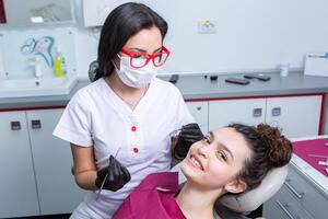 dentista examinando dentes do uma jovem mulher paciente dentro uma dental clínica. odontologia conceito. dentista e paciente dentro a dental escritório. foto