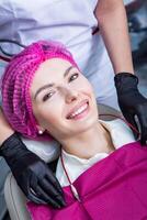 dentista examinando dentes do uma jovem mulher paciente dentro uma dental clínica. odontologia conceito. dentista e paciente dentro a dental escritório. foto