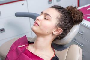 dentista examinando dentes do uma jovem mulher paciente dentro uma dental clínica. odontologia conceito. dentista e paciente dentro a dental escritório. foto