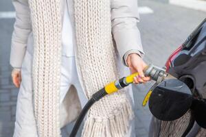 jovem mulher reabastecimento carro com Gasolina às gás estação. eco combustível conceito. a conceito do ambientalmente amigáveis transporte. foto