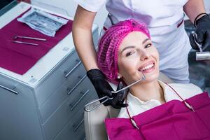 dentista examinando dentes do uma jovem mulher paciente dentro uma dental clínica. odontologia conceito. dentista e paciente dentro a dental escritório. foto