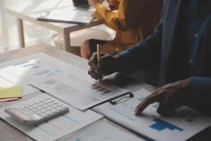 close-up da equipe de negócios analisando gráficos e gráficos de renda com computador portátil moderno. análise de negócios e conceito de estratégia. foto