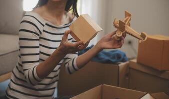 dois ásia blogueiro mostrando roupas dentro frente do a Câmera para gravação vlog vídeo viver transmissão às dela fazer compras. conectados compras carrinho noção. em sofá às casa foto