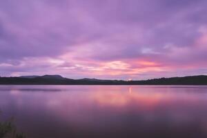 sereno águas uma feliz reflexão do uma lindo pastel lago e céu, Onde tranquilidade encontra da natureza paleta, criando uma harmonioso oásis do suave matizes e etéreo beleza foto