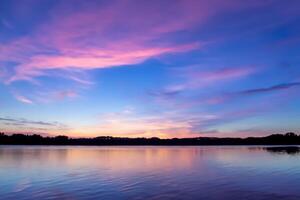 sereno águas uma feliz reflexão do uma lindo pastel lago e céu, Onde tranquilidade encontra da natureza paleta, criando uma harmonioso oásis do suave matizes e etéreo beleza foto