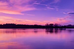 sereno águas uma feliz reflexão do uma lindo pastel lago e céu, Onde tranquilidade encontra da natureza paleta, criando uma harmonioso oásis do suave matizes e etéreo beleza foto