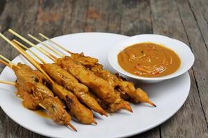 saciar dentro a beleza do lindo satay, Onde espetos do marinado deleite estão grelhado a carvão para dourado perfeição, oferta uma sinfonia do sabor dentro cada morder, uma culinária arte para saborear foto